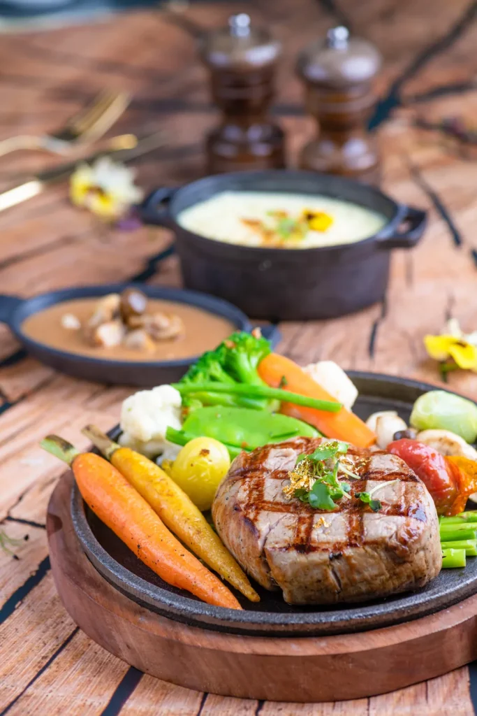 Sizzling grilled steak with vegetables and soup