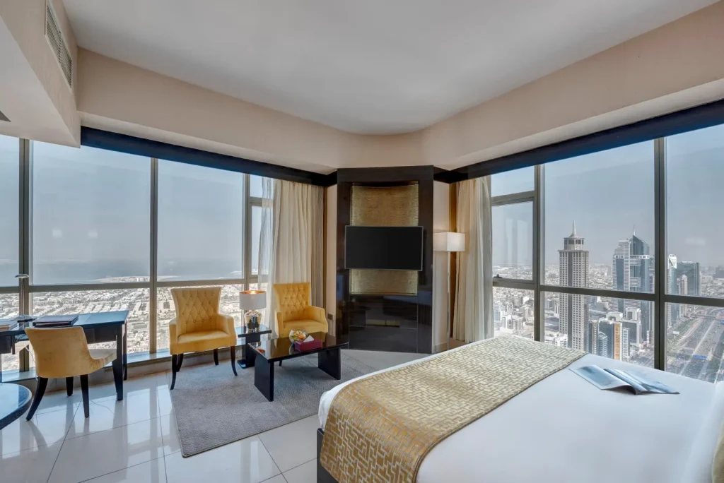 Corner room with king bed and floor-to-ceiling windows over Dubai, Gevora Hotel