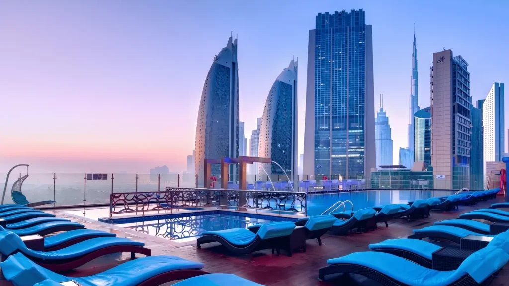 Overview Pool Lounge pool deck with sun loungers and the Sheikh Zayed Road skyline at sunset
