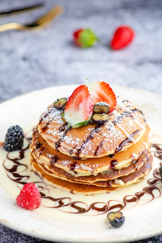 Pancake stack with fresh berries and chocolate sauce